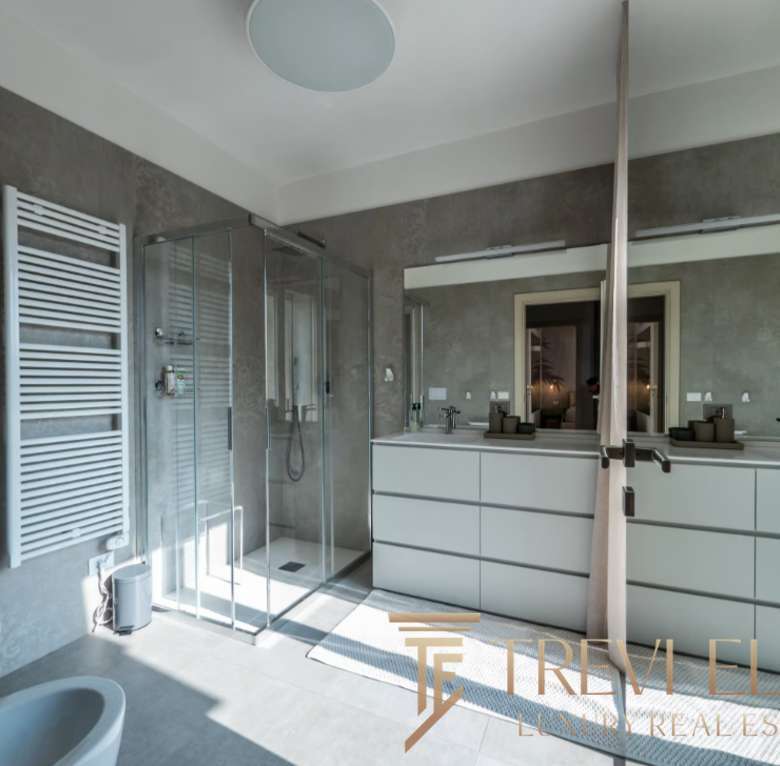 Современная ванная комната в элитном жилье с просторной душевой кабиной, стильной отделкой и зеркальными фасадами. Идеальный дизайн для комфортного и роскошного проживания.