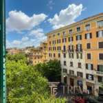 Высокий ракурс на классический жилой дом в центре Рима с зелеными деревьями и ярким голубым небом, демонстрирующий элитную недвижимость для клиентов Trévi Élite.