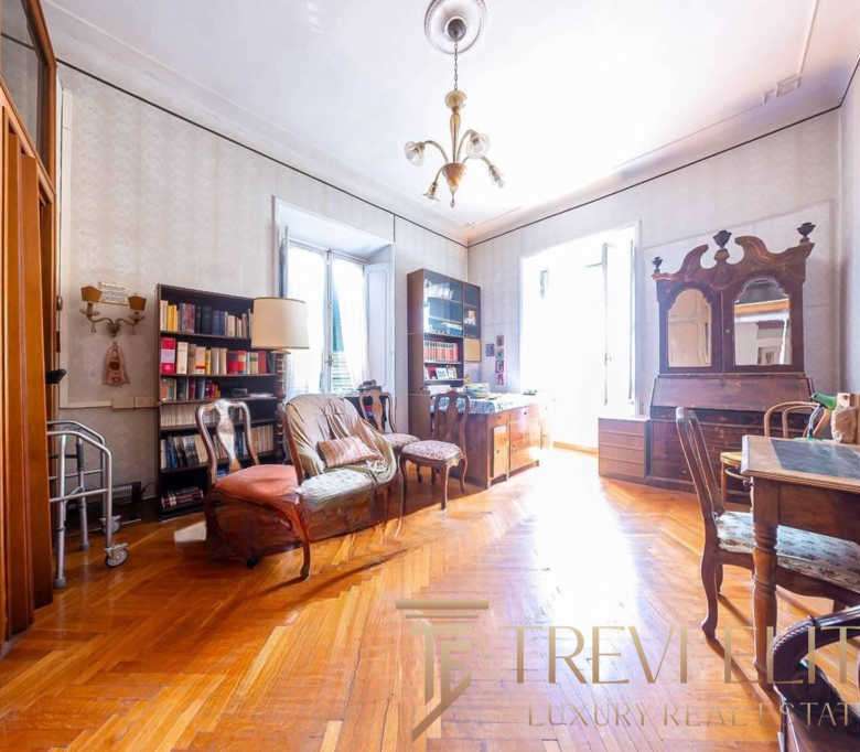 Элегантная гостиная с деревянной мебелью, ярким светом и антикварными предметами, создающая атмосферу уюта и классического стиля в высококлассной недвижимости.