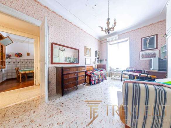 Уютная гостиная в классическом стиле с мягкой мебелью и украшениями, идеально подходит для отдыха и семейных встреч, обеспечивая комфорт и элегантность в роскошных итальянских апартаментах.