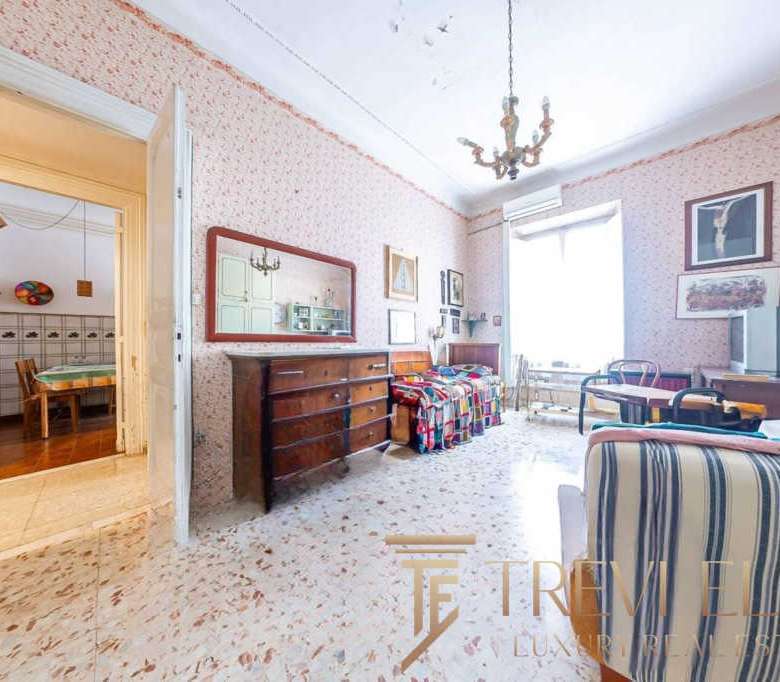 Уютная гостиная в классическом стиле с мягкой мебелью и украшениями, идеально подходит для отдыха и семейных встреч, обеспечивая комфорт и элегантность в роскошных итальянских апартаментах.