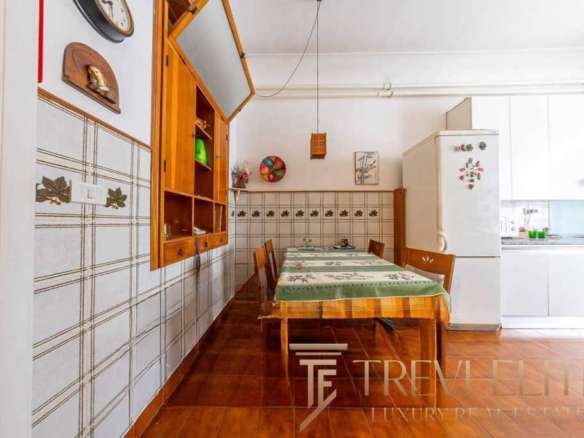 Кухня с деревянной мебелью и кафельной отделкой, уютное пространство для семейных обедов, светлые стены и современная техника, идеально подходит для проживания высокого класса.