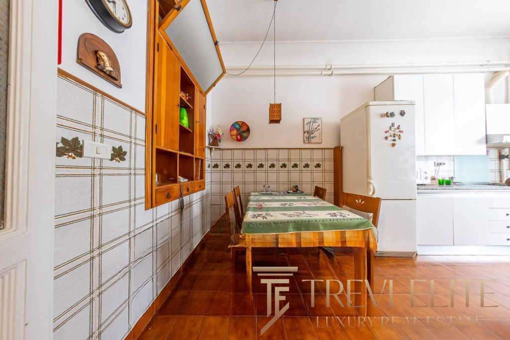 Кухня с деревянной мебелью и кафельной отделкой, уютное пространство для семейных обедов, светлые стены и современная техника, идеально подходит для проживания высокого класса.