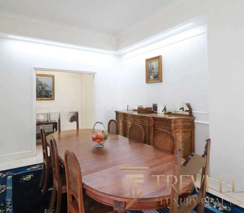 Современная роскошная обеденная зона с классической мебелью и элегантной декоративной отделкой, идеально подходящая для высококлассной недвижимости высокого уровня.