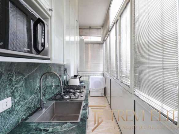 Современная кухня с панорамными окнами и встроенной техникой для элитных апартаментов на продаже.