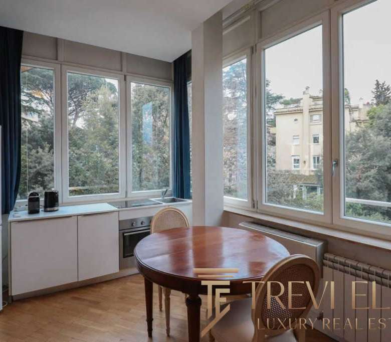 Современная кухня с большими окнами и уютным обеденным уголком, идеально подходящая для комфортного проживания в элитной недвижимости.