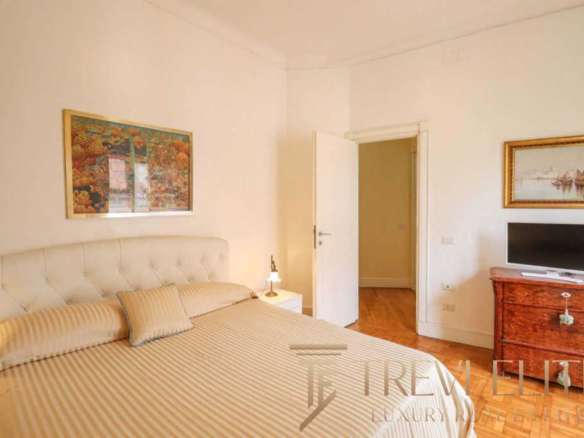 Роскошная спальня в элитной недвижимости с уютной кроватью и стильным интерьером, демонстрирующая высокий уровень комфорта и дизайна для премиальных клиентов.