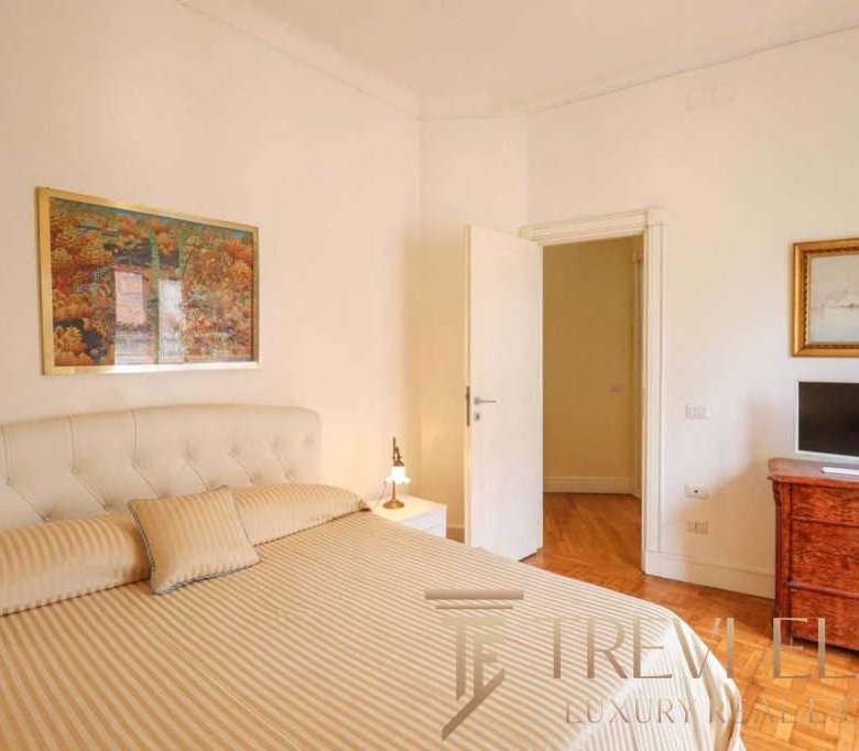 Роскошная спальня в элитной недвижимости с уютной кроватью и стильным интерьером, демонстрирующая высокий уровень комфорта и дизайна для премиальных клиентов.