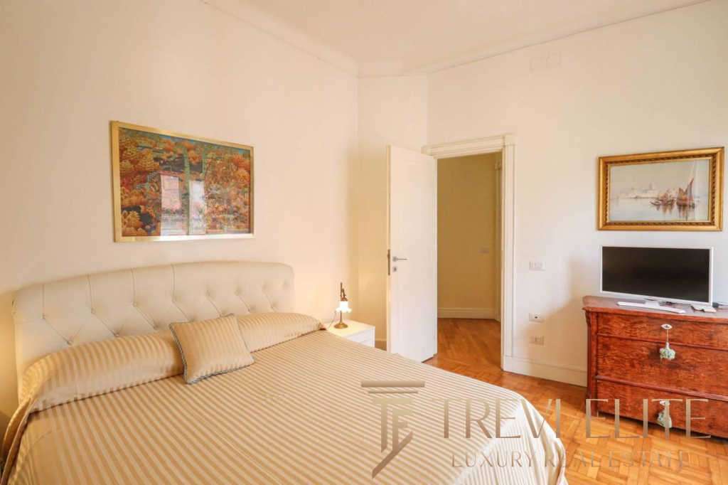 Роскошная спальня в элитной недвижимости с уютной кроватью и стильным интерьером, демонстрирующая высокий уровень комфорта и дизайна для премиальных клиентов.