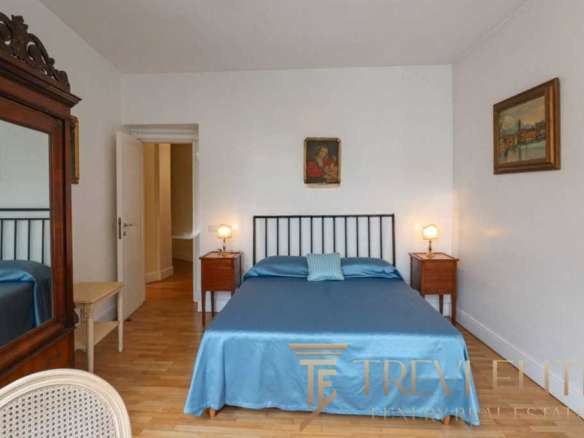 Элитная спальня в стиле классика с мягким одеялом и уютным освещением, демонстрирующая высокий стандарт жилищной роскоши.