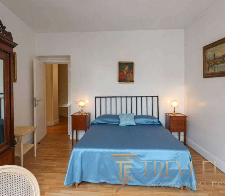 Элитная спальня в стиле классика с мягким одеялом и уютным освещением, демонстрирующая высокий стандарт жилищной роскоши.