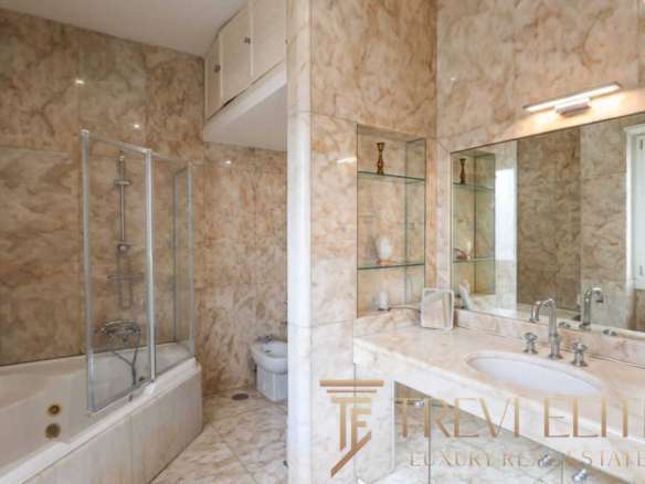 Роскошная ванная комната с мраморной отделкой, современной сантехникой и просторной системой душа. Элитный дизайн подчеркивает комфорт и стиль высокого уровня недвижимости.