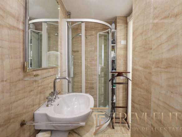 Современная ванная комната с душевой кабиной и стильными деталями, дизайн высокого класса, подходит для роскошных жилых помещений в элитных недвижимостьх.