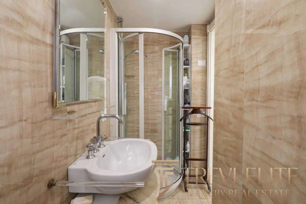 Современная ванная комната с душевой кабиной и стильными деталями, дизайн высокого класса, подходит для роскошных жилых помещений в элитных недвижимостьх.