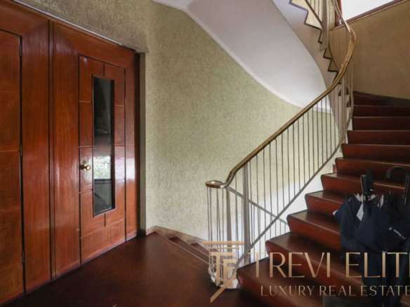 Современная деревянная дверь и кованая лестница в роскошном интерьере элитного дома. Идеальное решение для тех, кто ценит комфорт и стиль в недвижимости.