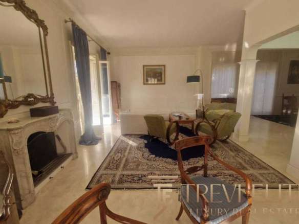 Элегантная гостиная с классической мебелью, каминов и уютной атмосферой, идеально подходящей для престижной жизни в роскошной недвижимости.