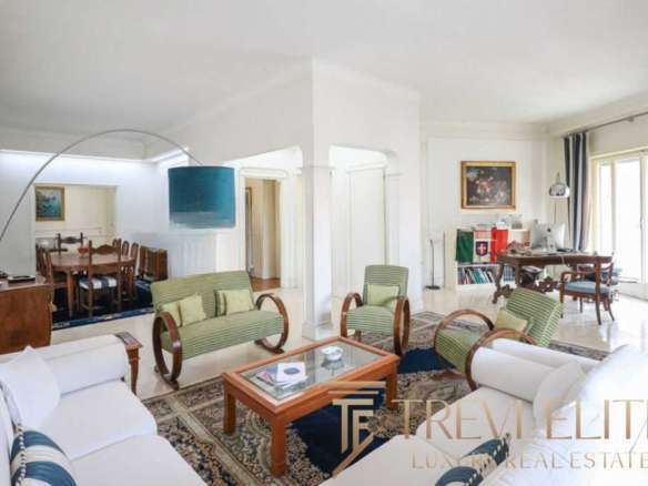 Уютная гостиная с мягкими диванами и креслами, светлые стены и большие окна создают атмосферу роскоши и комфорта в элитной недвижимости.