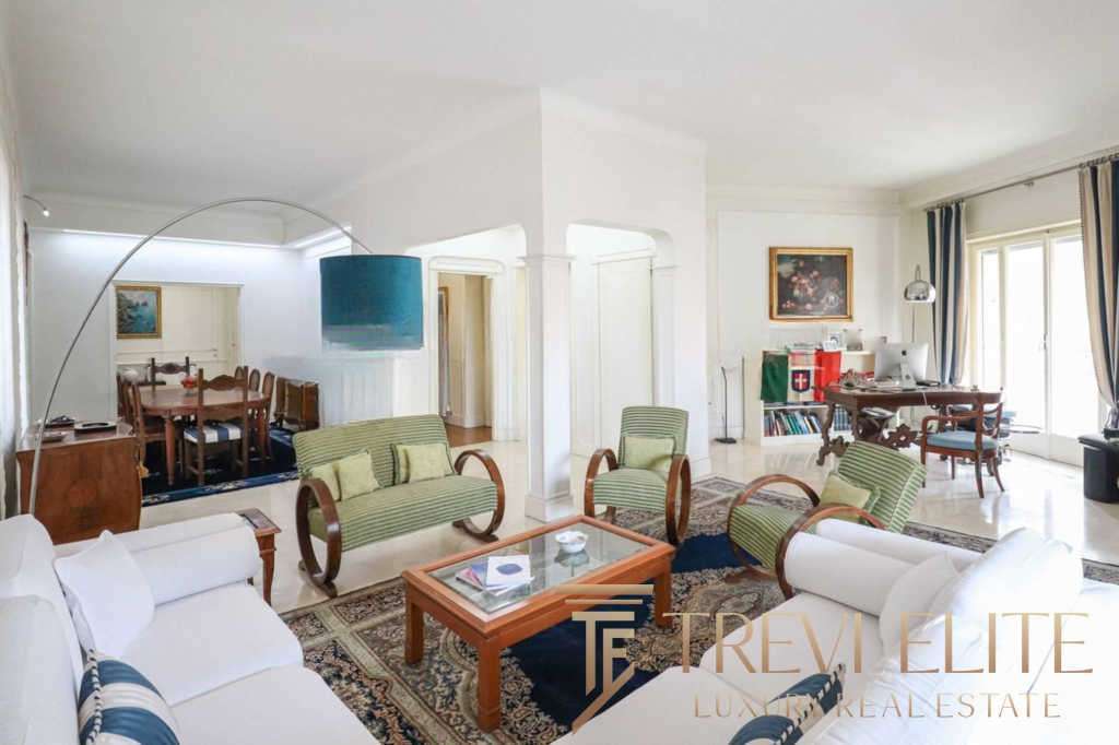 Уютная гостиная с мягкими диванами и креслами, светлые стены и большие окна создают атмосферу роскоши и комфорта в элитной недвижимости.