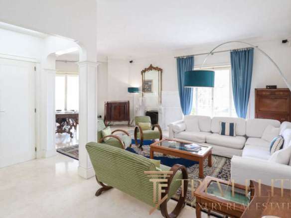 Роскошная гостиная в элитной недвижимости с современным интерьером, яркими голубыми шторами и уютными диванами, подчеркивающая эксклюзивность и высокое качество жилья.