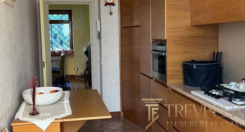 Современная кухонная зона в элитной недвижимости, выполненная из натурального дерева, с современными бытовыми приборами и уютным интерьером. Отличное пространство для комфортной жизни и приема гостей.