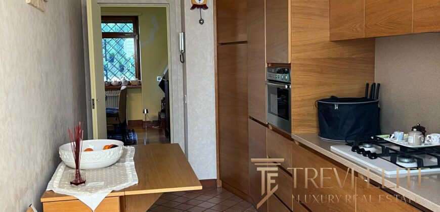 Современная кухонная зона в элитной недвижимости, выполненная из натурального дерева, с современными бытовыми приборами и уютным интерьером. Отличное пространство для комфортной жизни и приема гостей.