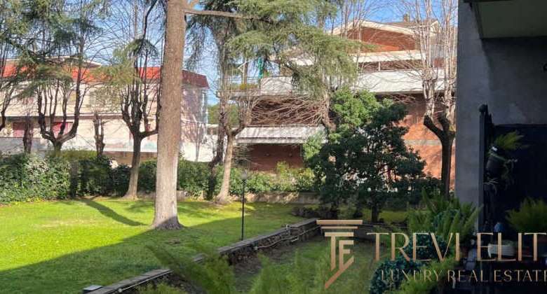 Современный зеленый сад с деревьями и ухоженной травой, рядом с элитным жилым комплексом и уютной зоной отдыха, предложение эксклюзивной недвижимости от агентства Треви Элит.