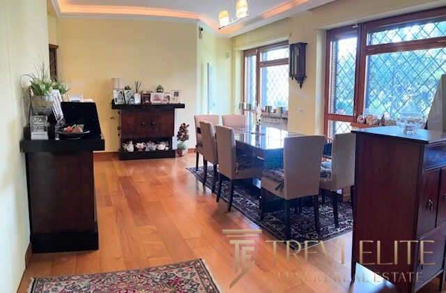 Оффтоповая гостиная с большими окнами, уютным интерьером и просторной зоной для приема гостей, идеально подходящей для элитной недвижимости.