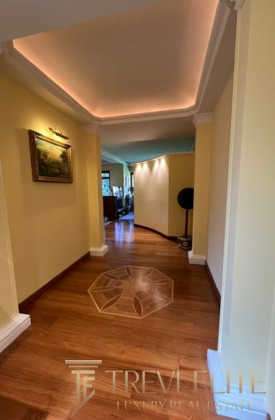 Элегантный интерьер роскошной квартиры с гармоничным освещением и изысканным дизайном, создающий атмосферу уюта и эксклюзивности.