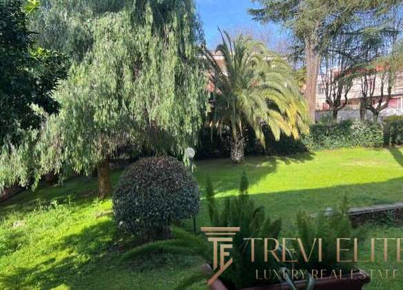 Уютный зелёный сад с разнообразными деревьями и кустами в роскошной недвижимости, предлагаемой агентством Треви Элит.