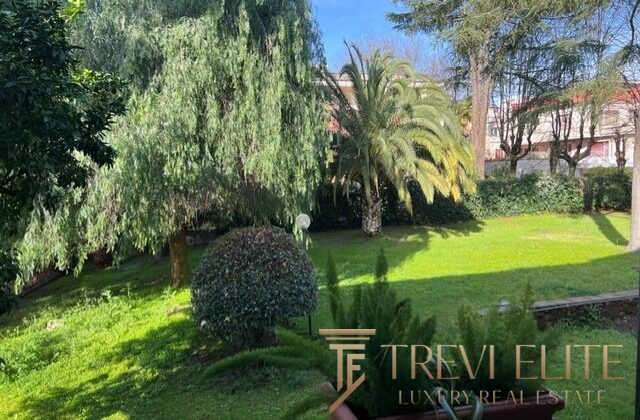Уютный зелёный сад с разнообразными деревьями и кустами в роскошной недвижимости, предлагаемой агентством Треви Элит.