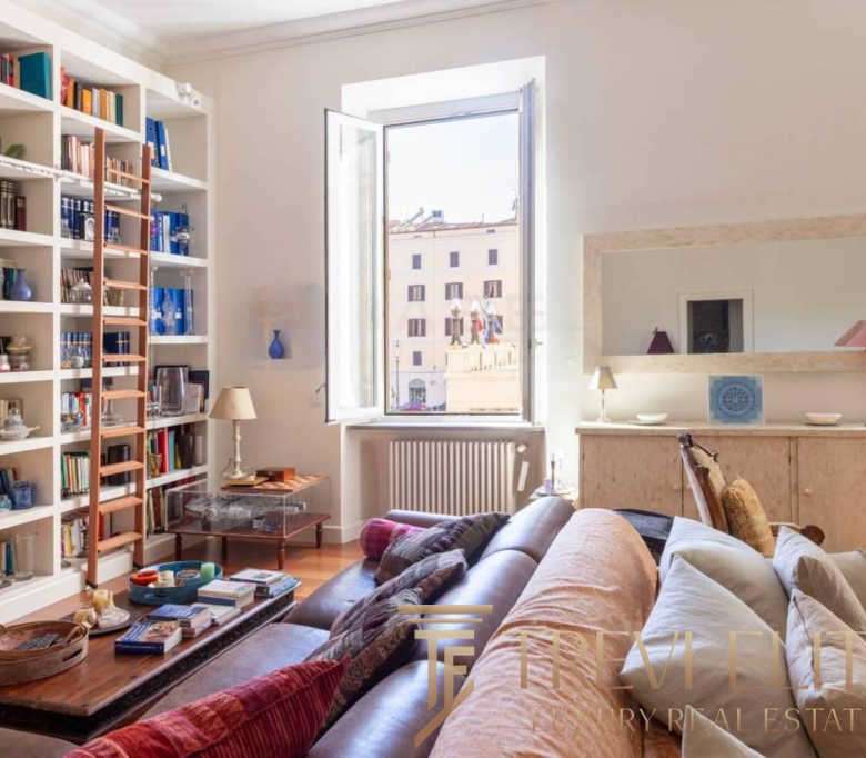 Элегантная гостиная с уютным диваном, книжной полкой и светлым интерьером в современном жилом пространстве.