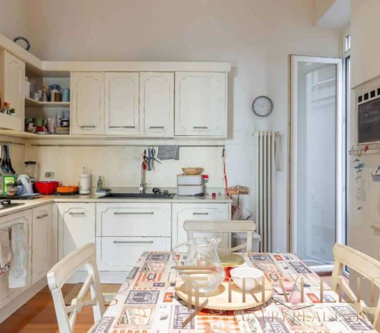 Уютная кухня в светлых тонах с современной мебелью и яркими декоративными элементами, создающая теплую хозяйственную атмосферу и комфорт для семейных обедов и завтраков.