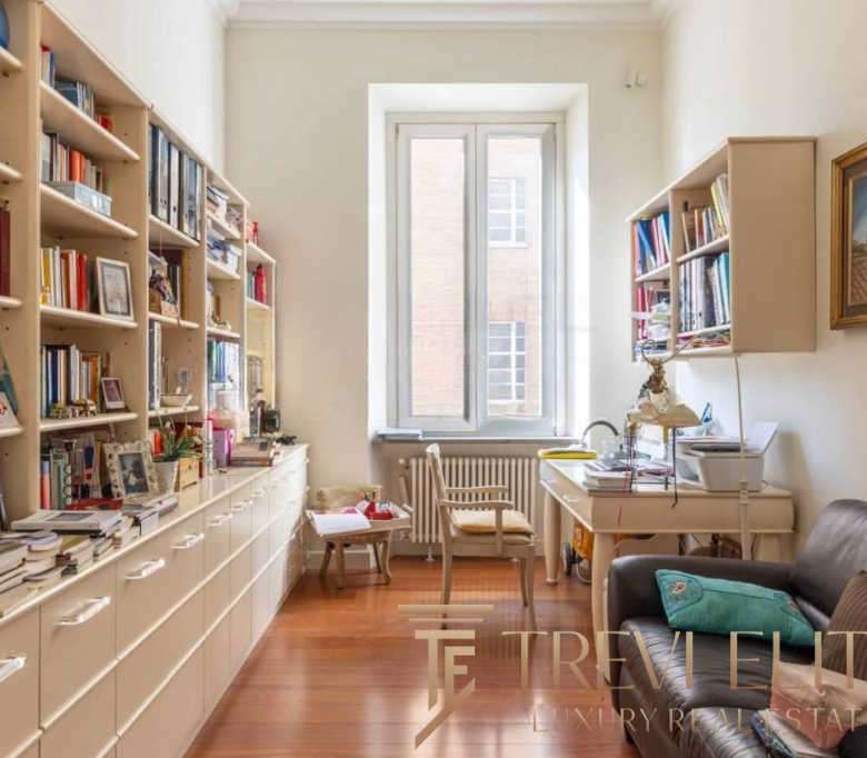 Картинка интерьера уютной квартиры с книжными полками, письменным столом и диваном, идеально отражающая комфорт и стиль для элитной недвижимости.