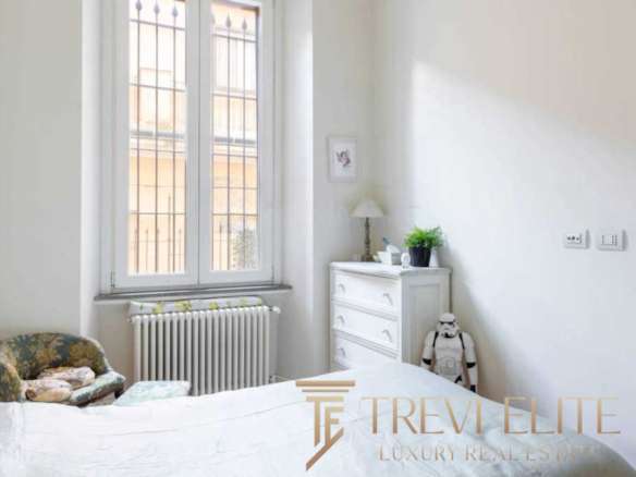 Высококлассная недвижимость в Италии, элегантная спальня с большим окном и классической мебелью, идея для ценителей роскошных интерьеров и эксклюзивных предложений от агентства Треви Элит.