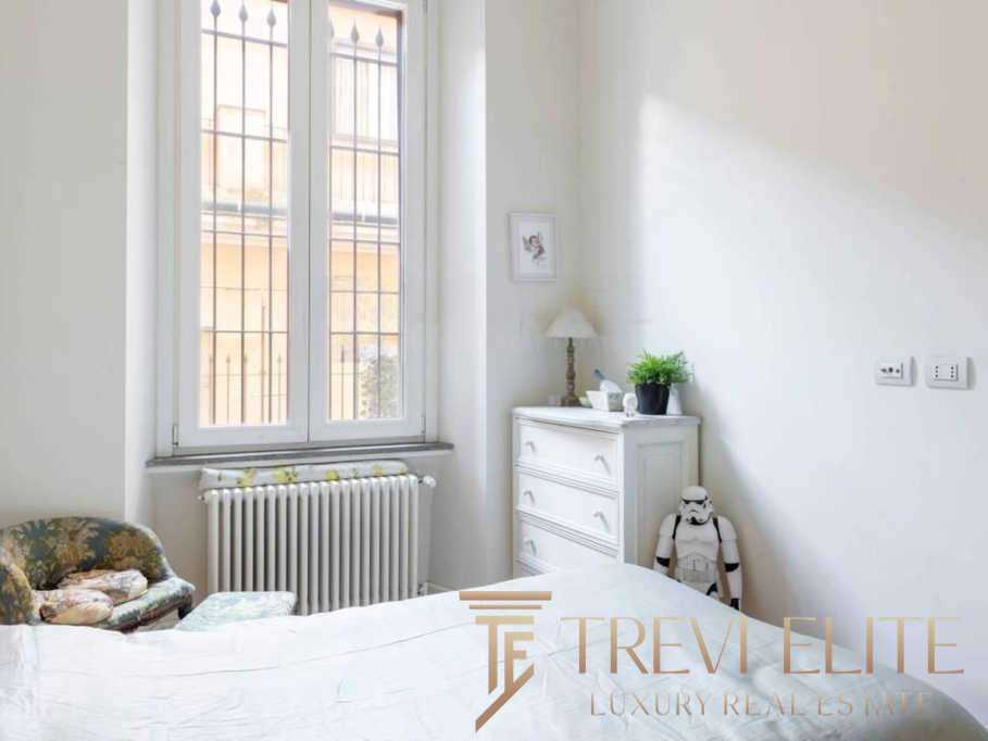 Высококлассная недвижимость в Италии, элегантная спальня с большим окном и классической мебелью, идея для ценителей роскошных интерьеров и эксклюзивных предложений от агентства Треви Элит.