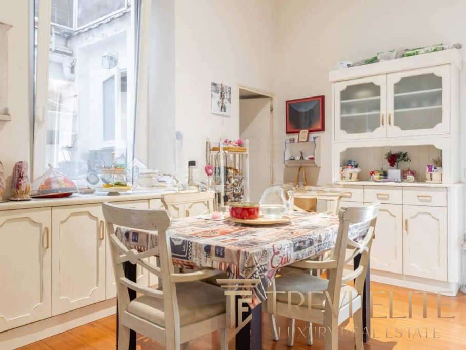 Уютная кухня с большим столом, обставленная в светлых нейтральных тонах, идеальное место для семейных обедов и встреч с друзьями, яркое и гармоничное пространство.