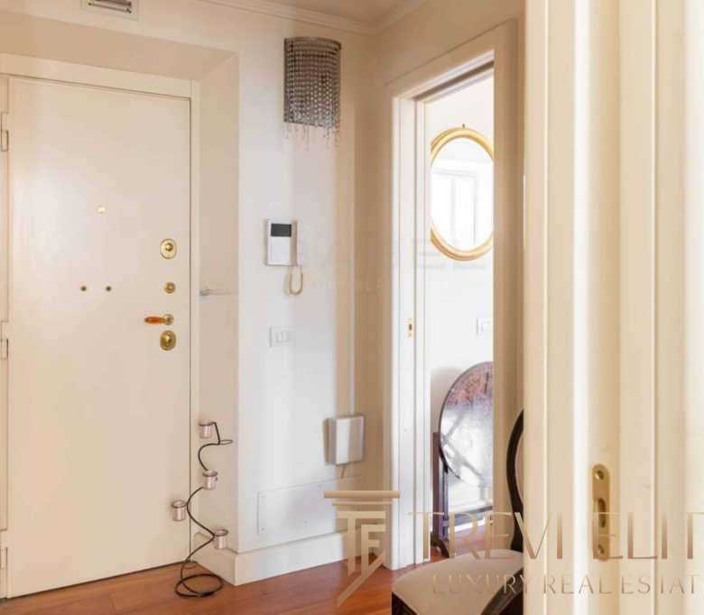 Высококачественная входная дверь в роскошной квартире, современный интерьер, чистый и светлый холл, стильные элементы дизайна, расположение в элитном доме недалеко от центра.