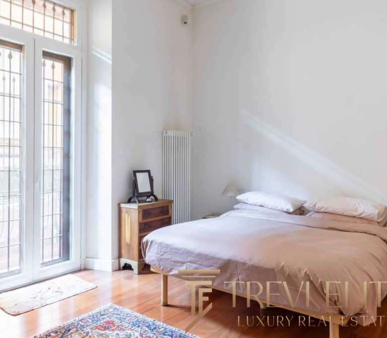 Уютная спальная комната с большим балконом, светлым интерьером и мягким постельным бельем, идеально подходящая для стильной жизни и высокого комфорта.