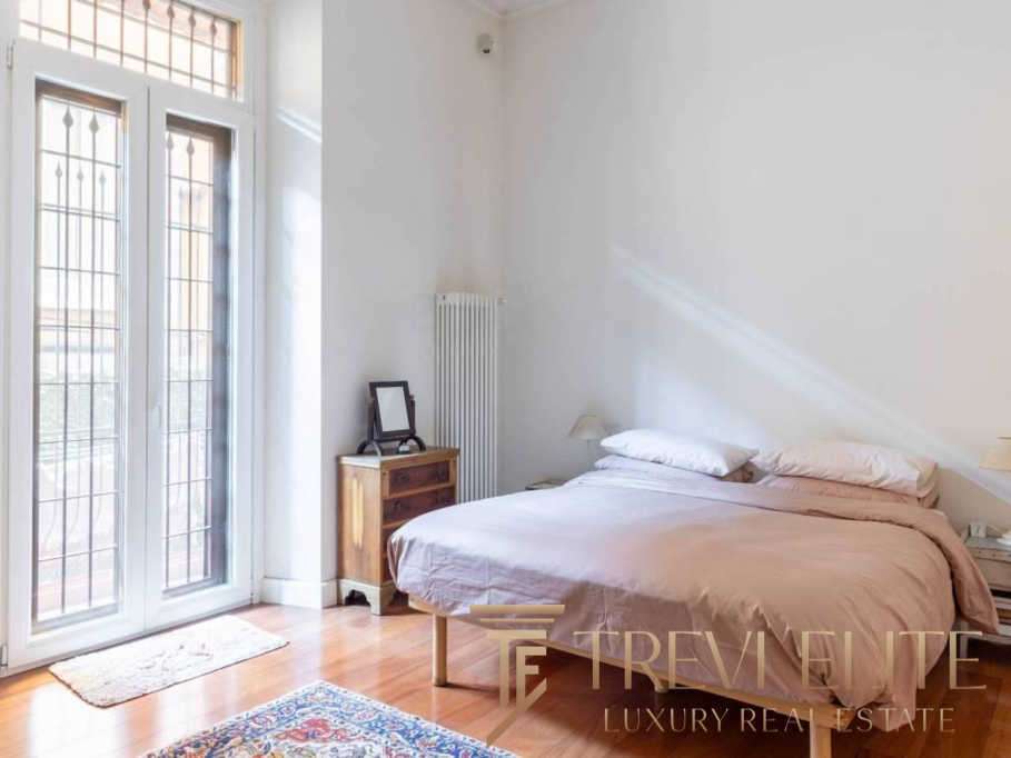 Уютная спальная комната с большим балконом, светлым интерьером и мягким постельным бельем, идеально подходящая для стильной жизни и высокого комфорта.