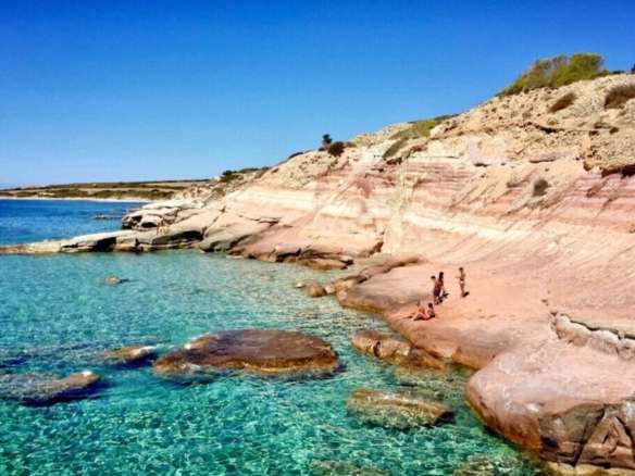 Коралловые скалы и кристально чистая голубая вода на берегу, идеальное место для отдыха и наслаждения природой. Великолепный пейзаж для ценителей морской красоты и уединения.