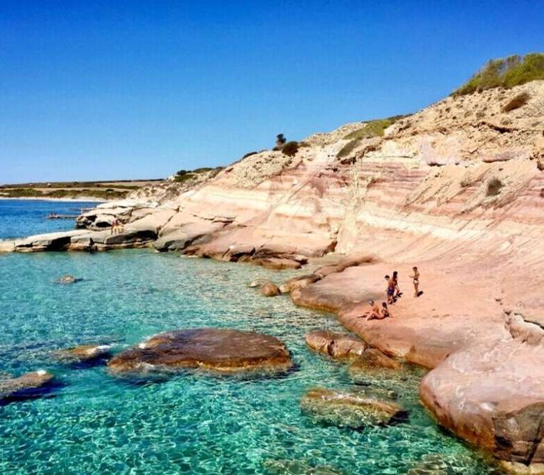 Коралловые скалы и кристально чистая голубая вода на берегу, идеальное место для отдыха и наслаждения природой. Великолепный пейзаж для ценителей морской красоты и уединения.