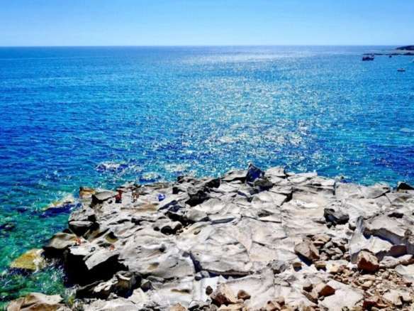 Заставка на берегу моря с ярко-синевой водой и каменистым берегом, высококлассная недвижимость в Италии, эксклюзивное агентство Треви Элит, элитная недвижимость и виды на побережье.