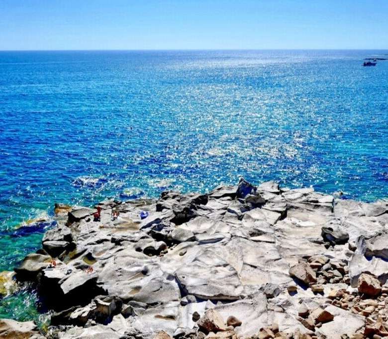 Заставка на берегу моря с ярко-синевой водой и каменистым берегом, высококлассная недвижимость в Италии, эксклюзивное агентство Треви Элит, элитная недвижимость и виды на побережье.