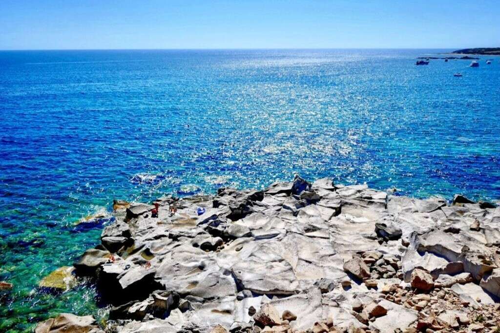 Заставка на берегу моря с ярко-синевой водой и каменистым берегом, высококлассная недвижимость в Италии, эксклюзивное агентство Треви Элит, элитная недвижимость и виды на побережье.