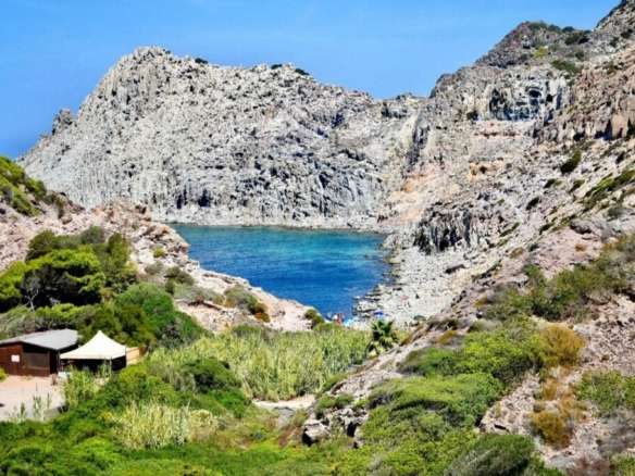 Уединенный залив на скалистом побережье с кристально чистой водой и живописной природой. Идеальное место для покупки роскошной недвижимости у моря в Италии.