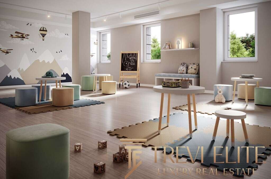 Уютная детская комната с мягкими сиденьями, игровой доской и яркой стеной с горным пейзажем, создающая теплую и безопасную атмосферу для малышей.