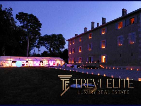 Элегантное ночное изображение роскошного особняка с подсвеченными окнами и зоной для мероприятий под звездным небом, рекламирующее агентство недвижимости Треви Элит.