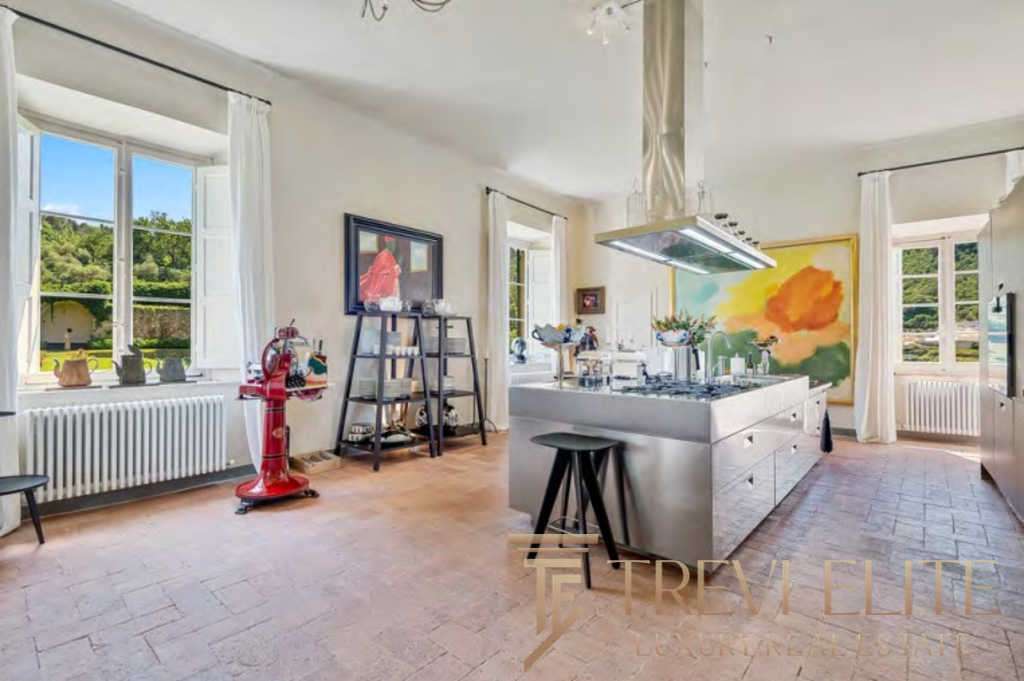 Роскошная кухня с большими окнами, светлыми стенами и стильной мебелью, создающая уютную атмосферу для отдыха и приготовления пищи. Идеальное пространство для ценителей элитной недвижимости.