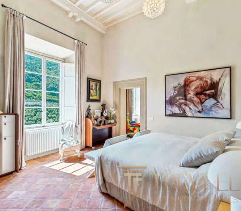 Роскошная спальня в элитной недвижимости с большими окнами и видом на природу, стильным интерьером и мебелью высокого класса, идеально подходит для комфортного проживания высокого уровня.