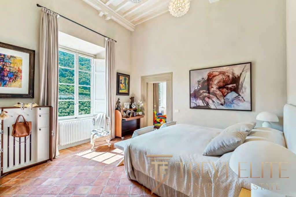 Роскошная спальня в элитной недвижимости с большими окнами и видом на природу, стильным интерьером и мебелью высокого класса, идеально подходит для комфортного проживания высокого уровня.